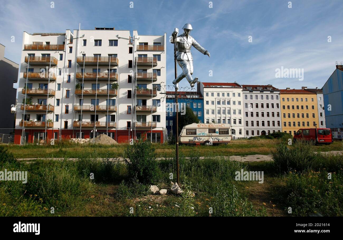 A view of the sculpture "Mauerspringer" (Walljumper), made by Florian and Michael Brauer and Edward Anders, on the so-called 'death strip', no man's land, of the former Berlin Wall site at the Bernauer Strasse, July 29, 2009. The sculpture is based on the photograph showing former East German border soldier Hans Conrad Schumann jumping over a barbed wire at the Bernauer Strasse on August 15, 1961 to escape from East Berlin to West Berlin. REUTERS/Fabrizio Bensch (GERMANY POLITICS CITYSCAPE ANNIVERSARY) Stock Photo