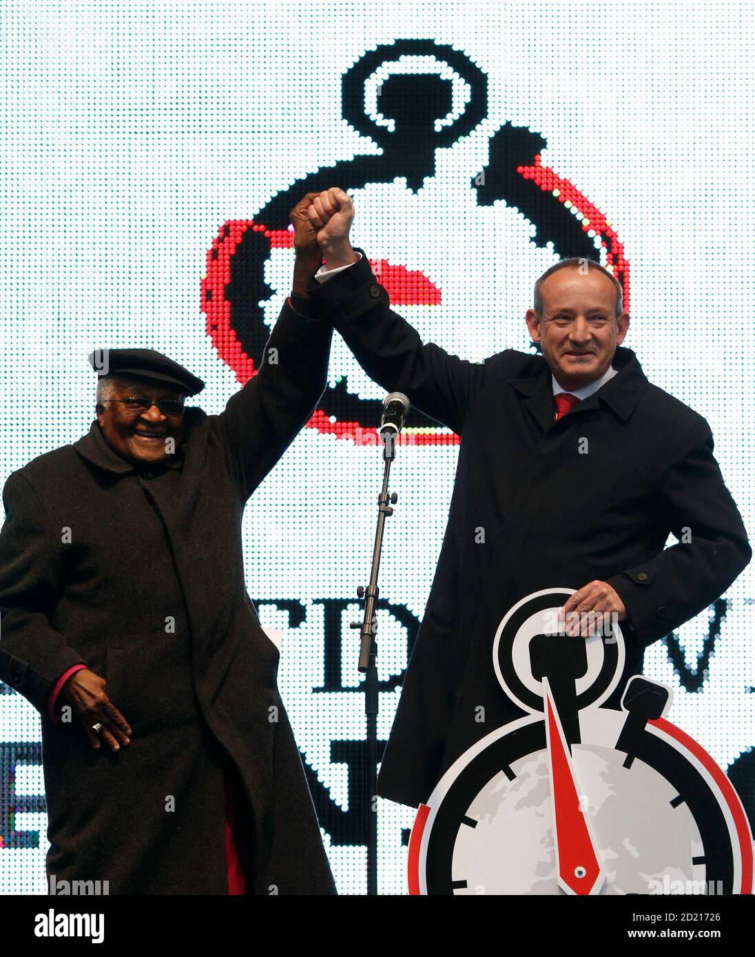 Archbishop Desmond Tutu hands over a petition signed by 512,894 people to  United Nations climate chief Yvo de Boer (R) on a stage in central  Copenhagen December 13, 2009. Copenhagen is the