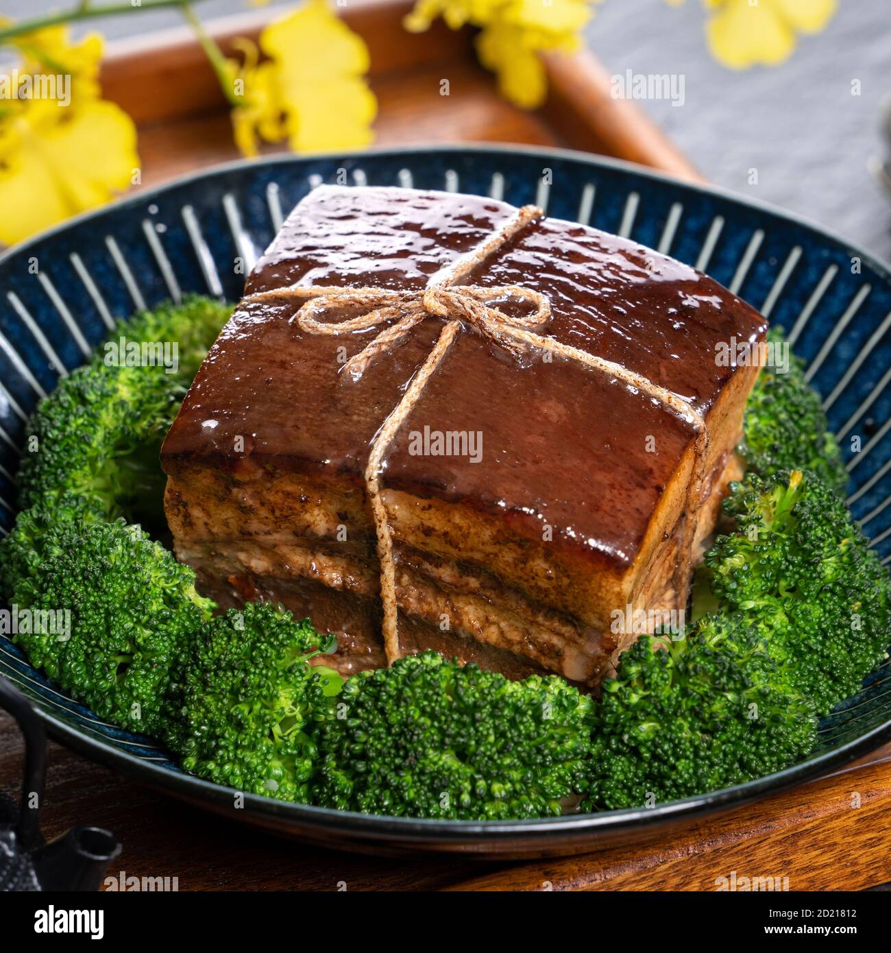 Dong Po Rou (Dongpo pork meat) in a beautiful plate with green vegetable, traditional festive food for Chinese new year cuisine meal, close up. Stock Photo