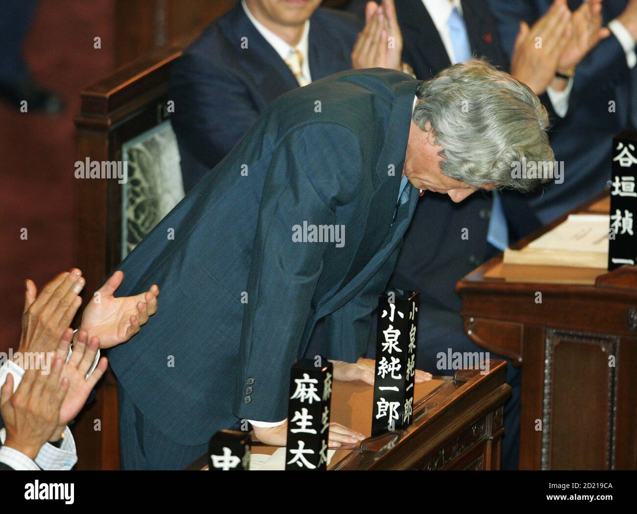 Japanese Prime Minister Junichiro Koizumi bows as he is applauded by fellow parliamentarians upon being re-elected prime minister at a special session of parliament in Tokyo September 21, 2005. The confirmation of the re-appointment cleared the way for Koizumi to press on with a reform programme including privatisation of the postal system after his party's landslide election victory this month. REUTERS/Issei Kato  ES/mk Stock Photo