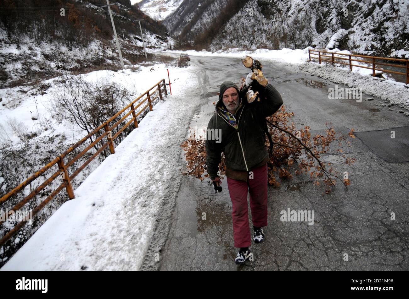 Bosnian Croat Zarko Hrgic, 51, carries wood from forest in the village of Babino January 31, 2010. Hrgic has been living in a cave for three years in Babino near the central Bosnian town of Zenica, 50 miles northeast of Sarajevo , where the temperature in the village dips to minus 17 degrees Celsius at night. He makes a living by selling wood for 15 euros ($20.80) per metre.  REUTERS/Dado Ruvic (BOSNIA AND HERZEGOVINA - Tags: SOCIETY ENVIRONMENT) Stock Photo