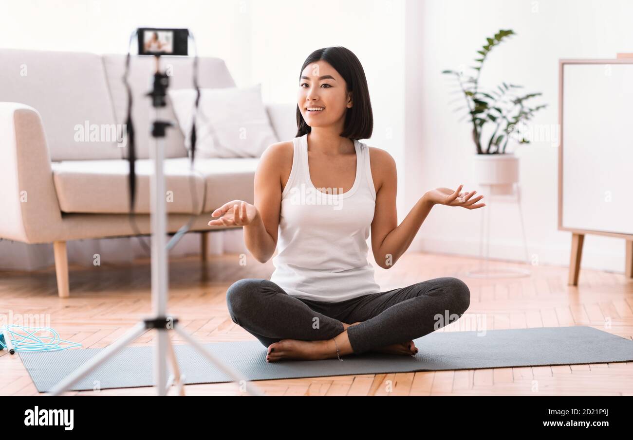 Sporty asian woman filming exercises for home training Stock Photo