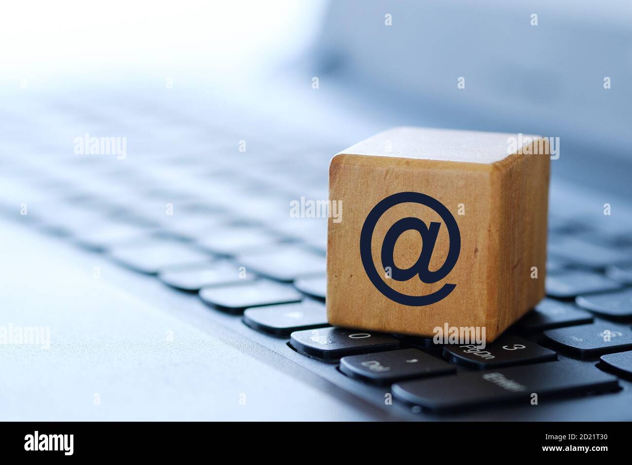 Internet symbol on a wooden cube on a computer keyboard, with a blurred ...