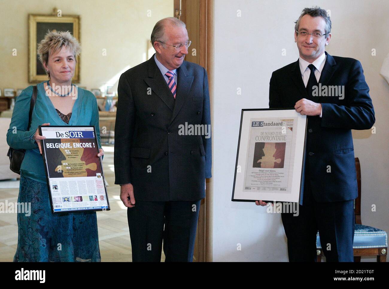 Belgian King Albert II (C) receives copies of Belgian French-speaking and  Dutch-speaking newspapers Le Soir and De Standaard from their  editors-in-chief Beatrice Delvaux (L) and Peter Vandermeersch at the  Brussels Royal Palace