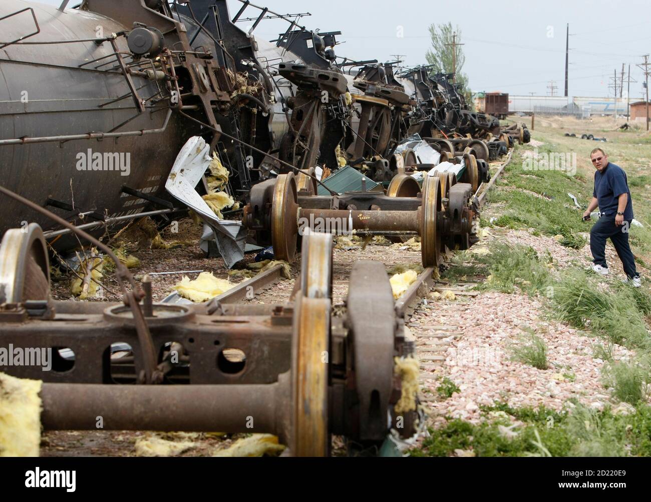 Curtis McFarlane looks at a tanker train blown off its wheels by a tornado in Windsor, Colorado May 22, 2008. Several tornados touched down in the area around lunchtime.  REUTERS/Rick Wilking (UNITED STATES) Stock Photo