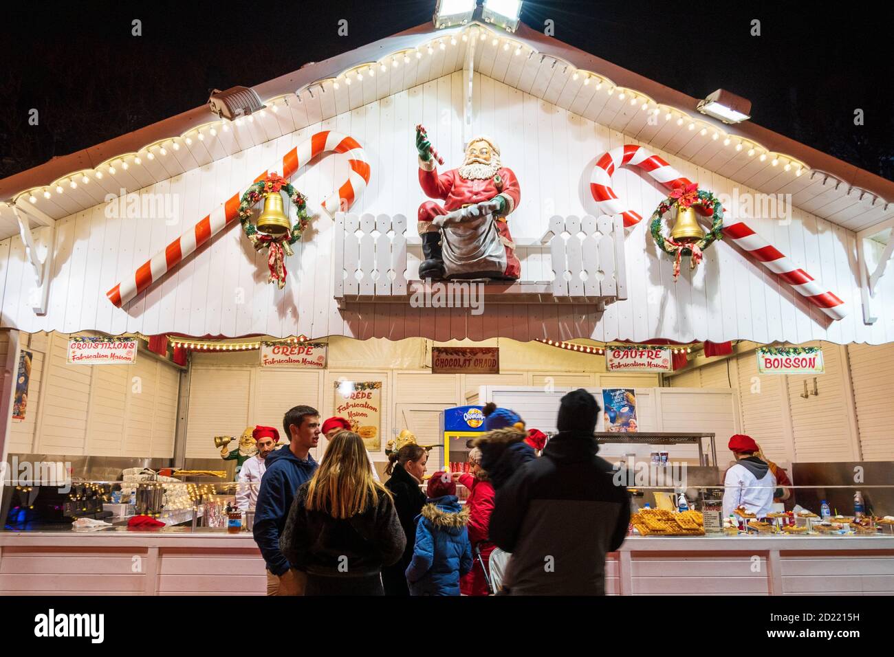 PARIS, FRANCE - JANUARY 6, 2019:  People with kids buy traditional fresh waffles and crepes, hot chocolate, mulled wine etc at Christmas market Stock Photo