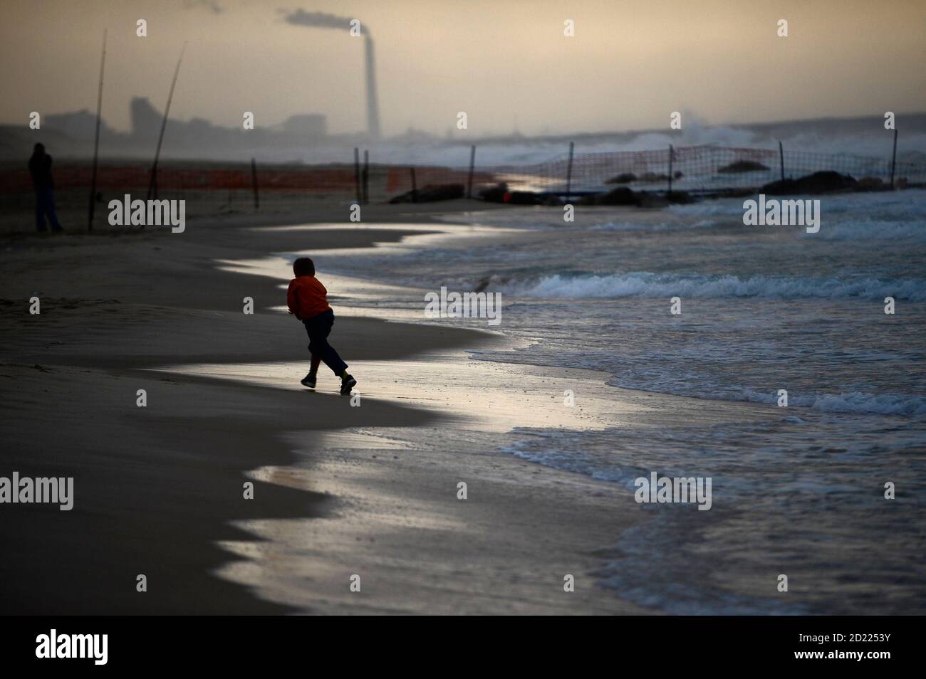 An Israeli boy plays on a rainy day at Nitzanim beach near the southern city of Ashkelon October 30, 2009. REUTERS/Amir Cohen (ISRAEL ENVIRONMENT SOCIETY) Stock Photo
