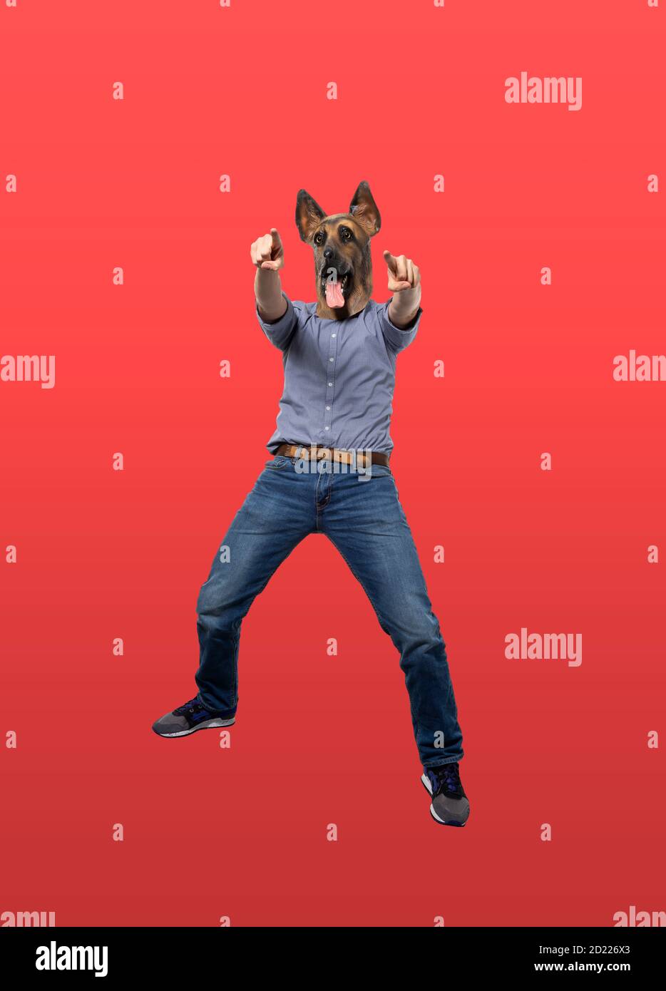 Man in dog mask pointing forward at camera. Full length. Isolated red