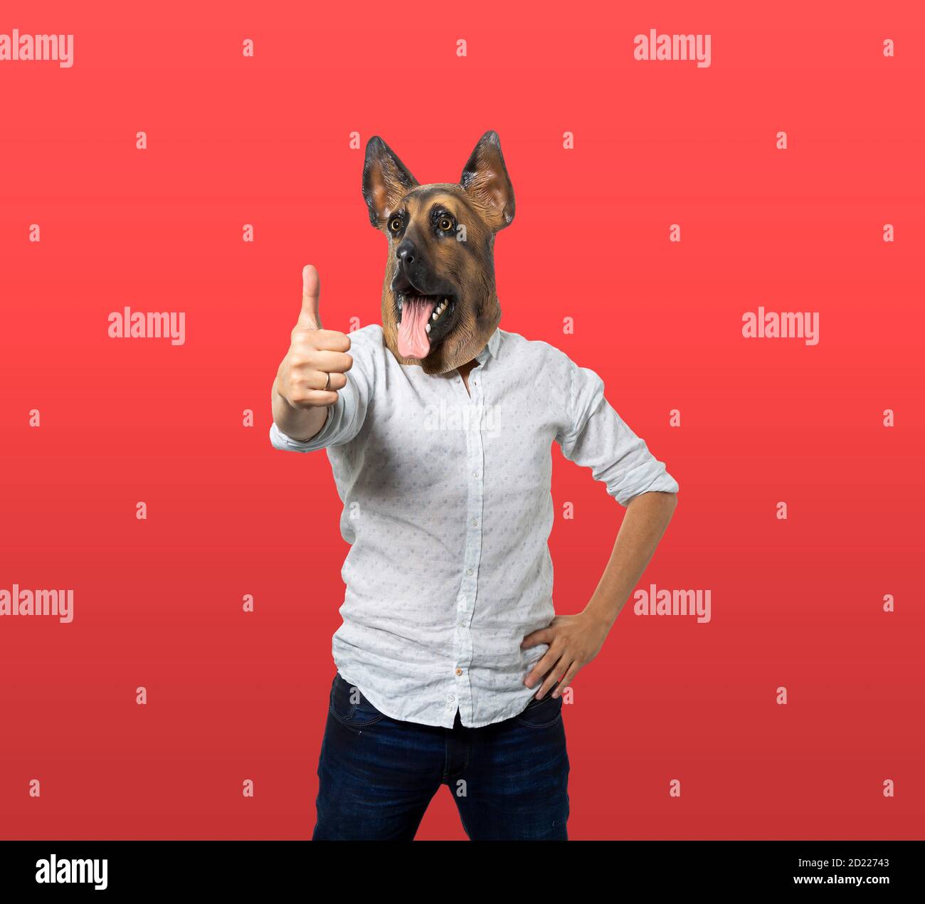 Man in dog mask giving thumbs up. Isolated red background. Medium shot