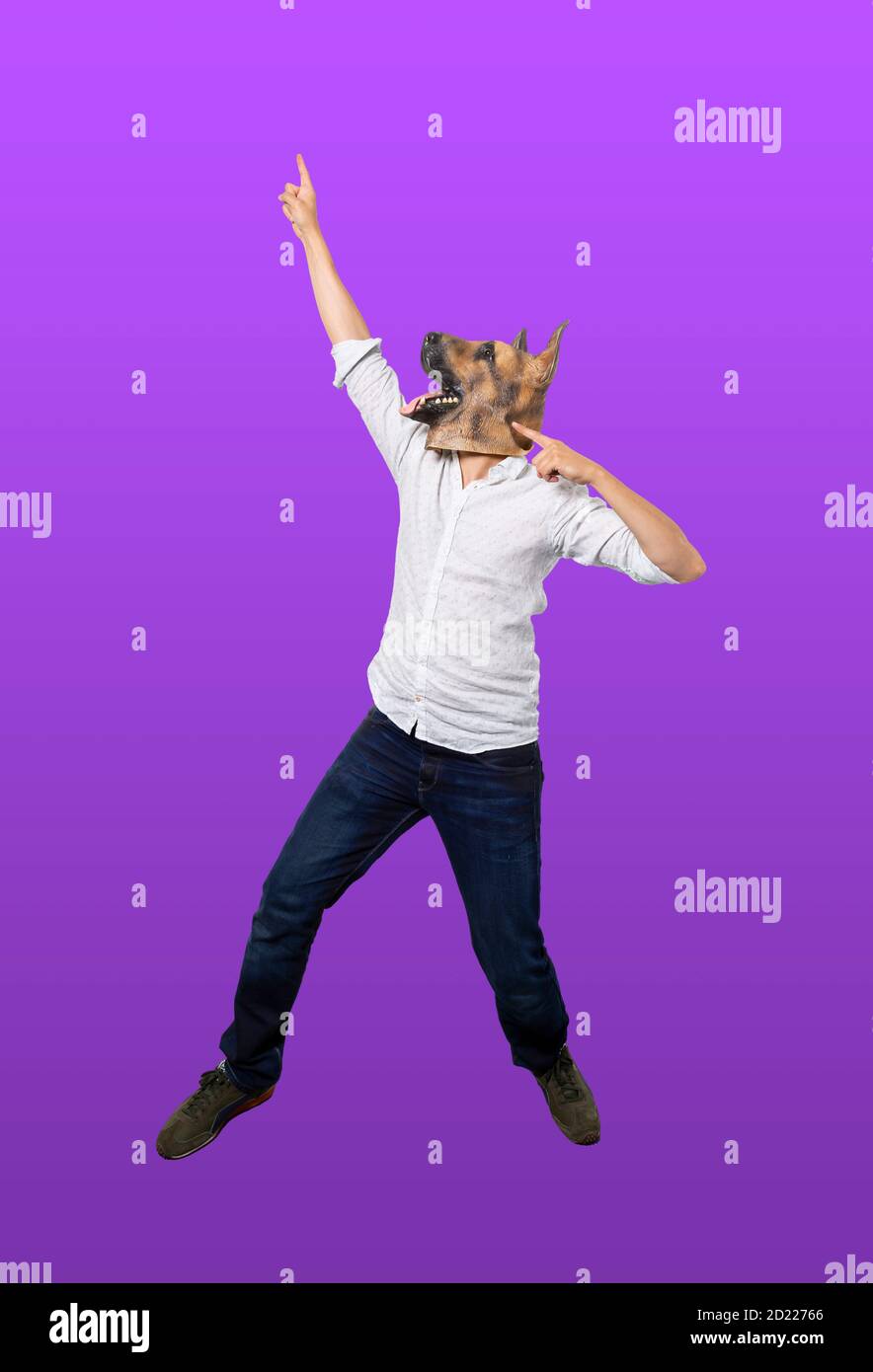 Man wearing dog mask pointing up in celebration pose. Isolated purple