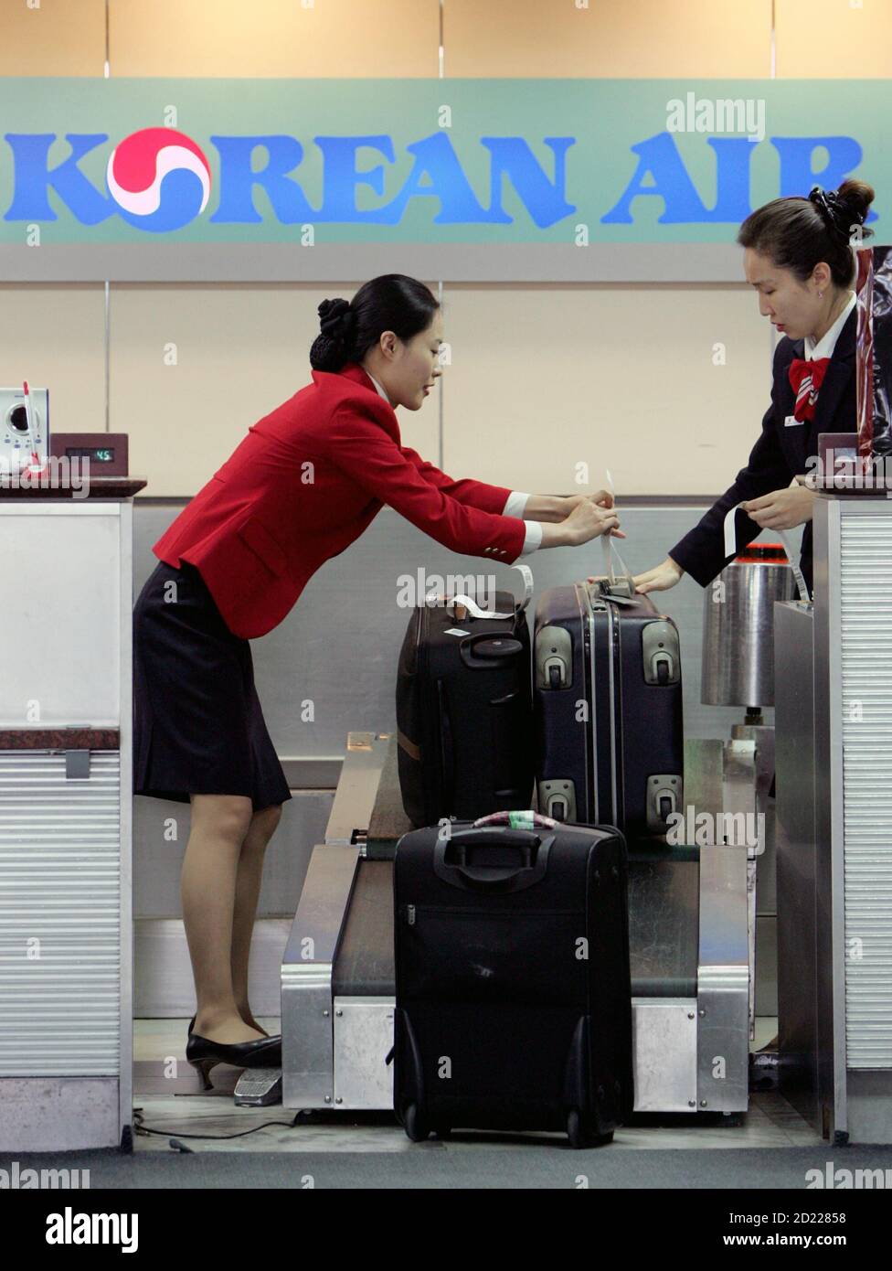 Korean Air check-in staffs tag passengers' luggage at Seoul's Kimpo airport  December 7, 2005. Unionised pilots at Korean Air Co. plan to strike from  Thursday after failing to reach a pay agreement