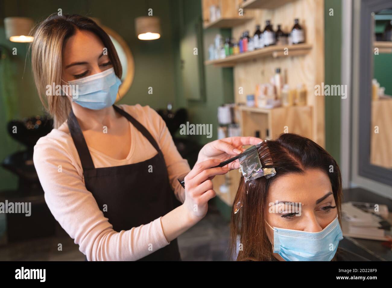 Female hairdresser wearing face mask dying hair of female customer at hair salon Stock Photo - Alamy Female hairdresser wearing face mask dying hair of female customer at hair salon Stock Photo - Alamy