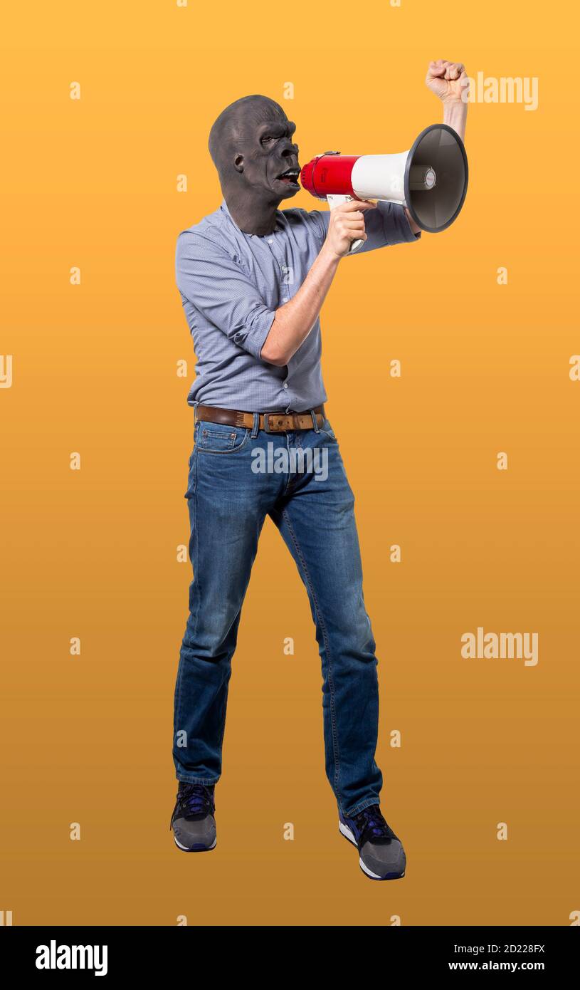 Man wearing gorilla mask using megaphone with raised fist. Isolated