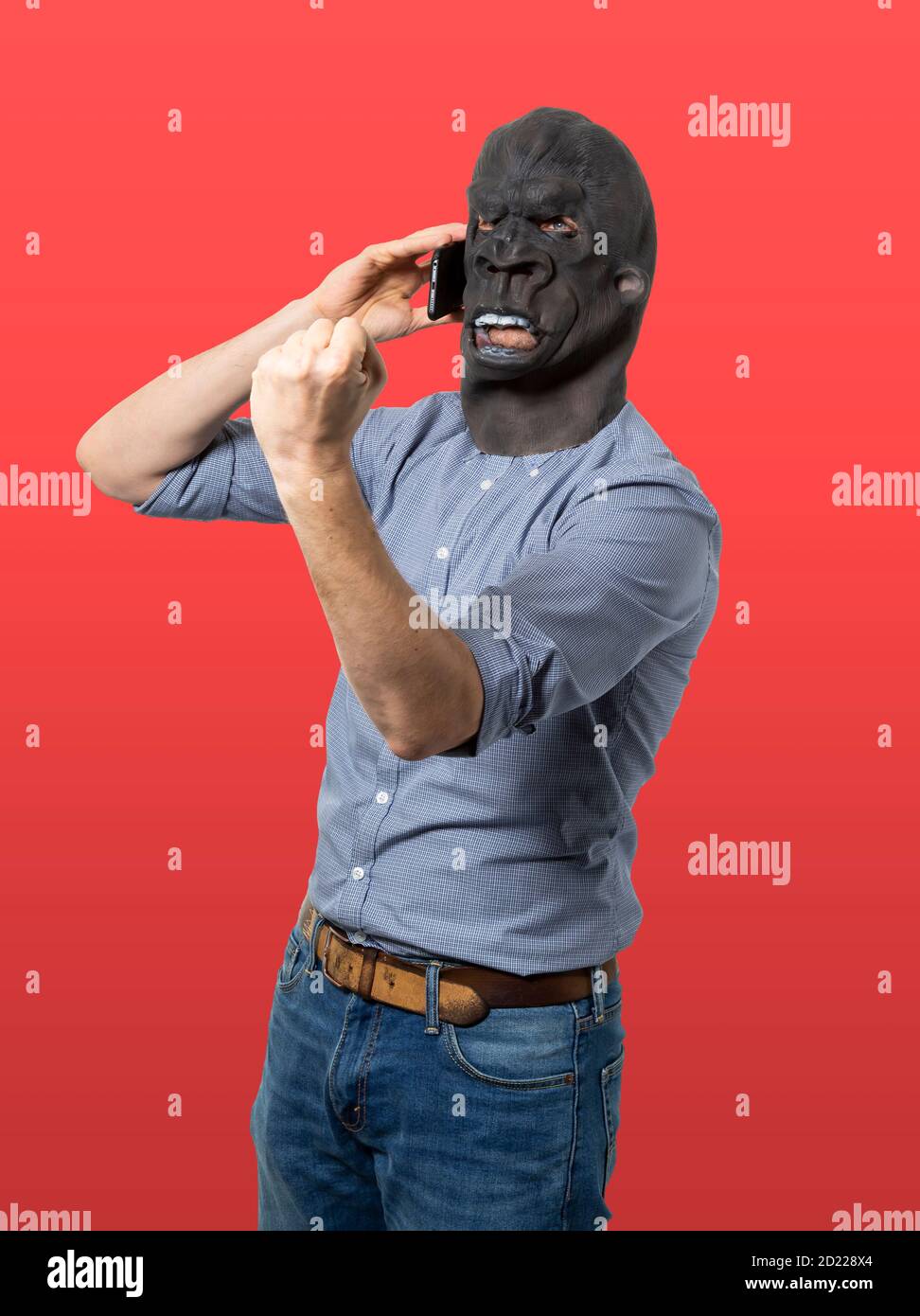 Man in gorilla mask talking on phone and shaking fist in anger