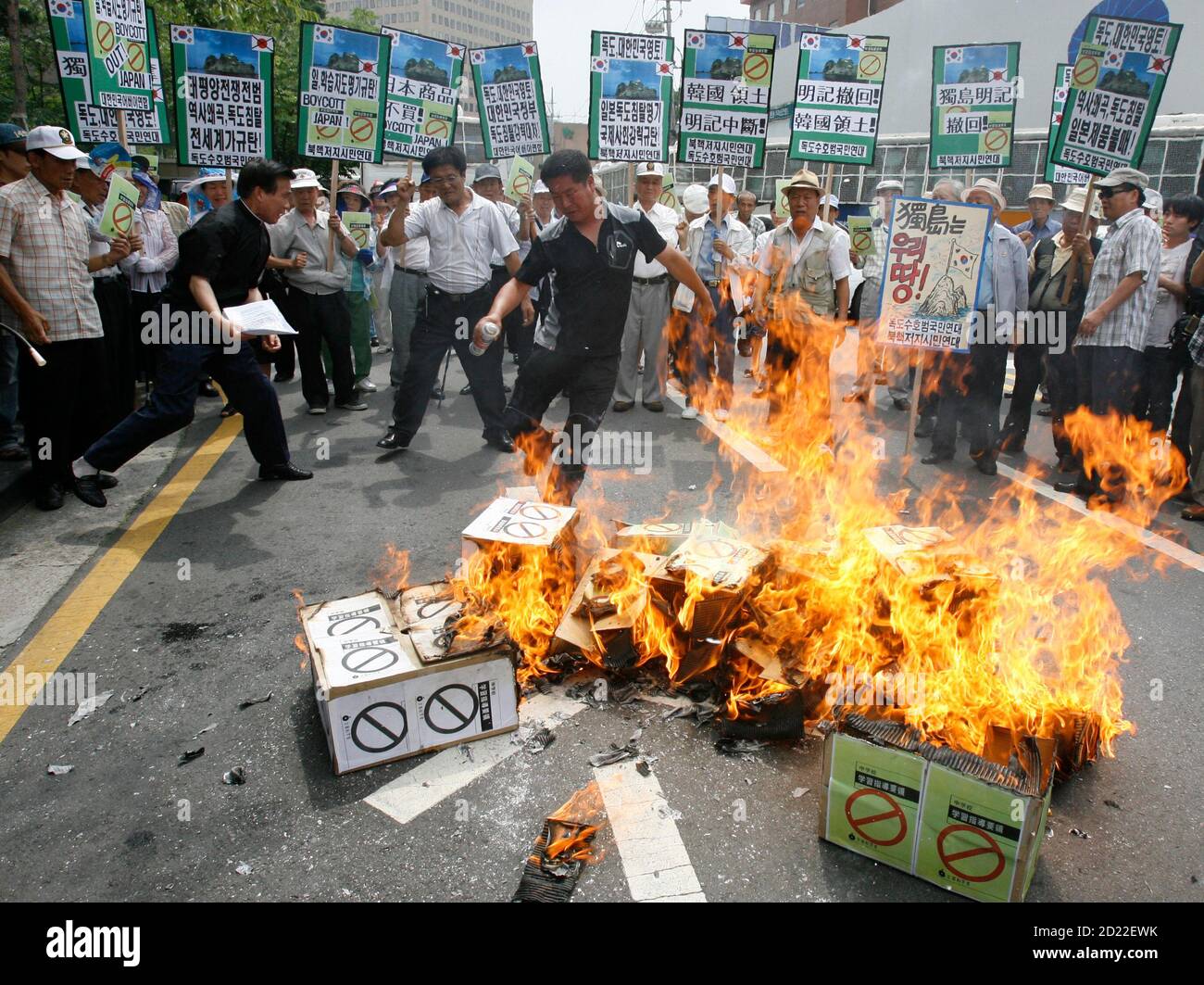Protesters burn signs representing Japan's middle school teaching guide at a demonstration denouncing Japan's sovereignty claim over a group of desolate volcanic islets Seoul and Pyongyang call Dokdo and Tokyo calls Takeshima, in front of the Japanese embassy in Seoul July 15, 2008. South Korea's coastguard said on Tuesday it had stepped up patrols near the islands, a day after Seoul recalled its ambassador in anger at new Japanese claims to the rocky outcrops. On Monday, Tokyo said it had told Seoul that it would refer in a middle school teaching guide to the islands as Japanese territory. Th Stock Photo