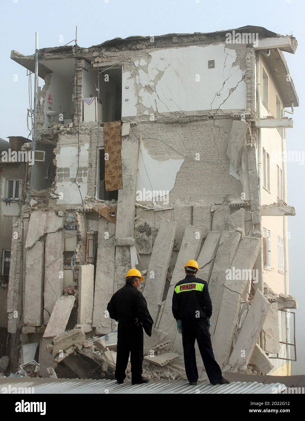 Albanian firefighters search for bodies after a building collapsed in Gjirokaster, some 250 km (156 miles) south of Tirana near the Greek border, November 10, 2008. Three people were trapped when a six-storey building collapsed on Sunday, injuring four people, according to local media. REUTERS/Arben Celi (ALBANIA) Stock Photo
