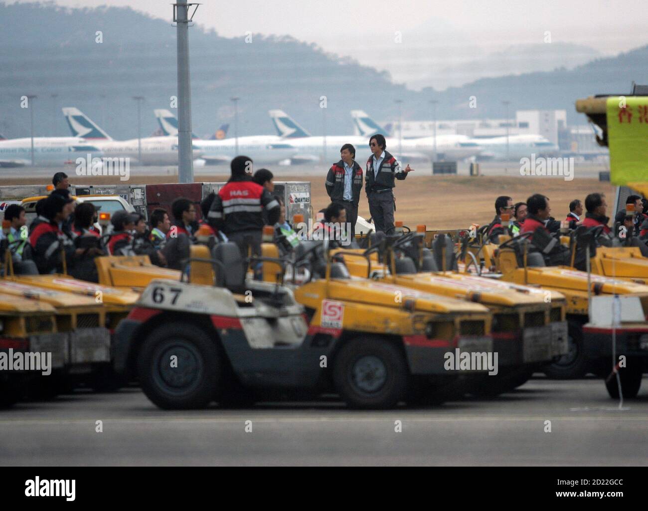 Baggage handlers gather near the baggage loading area to have a three