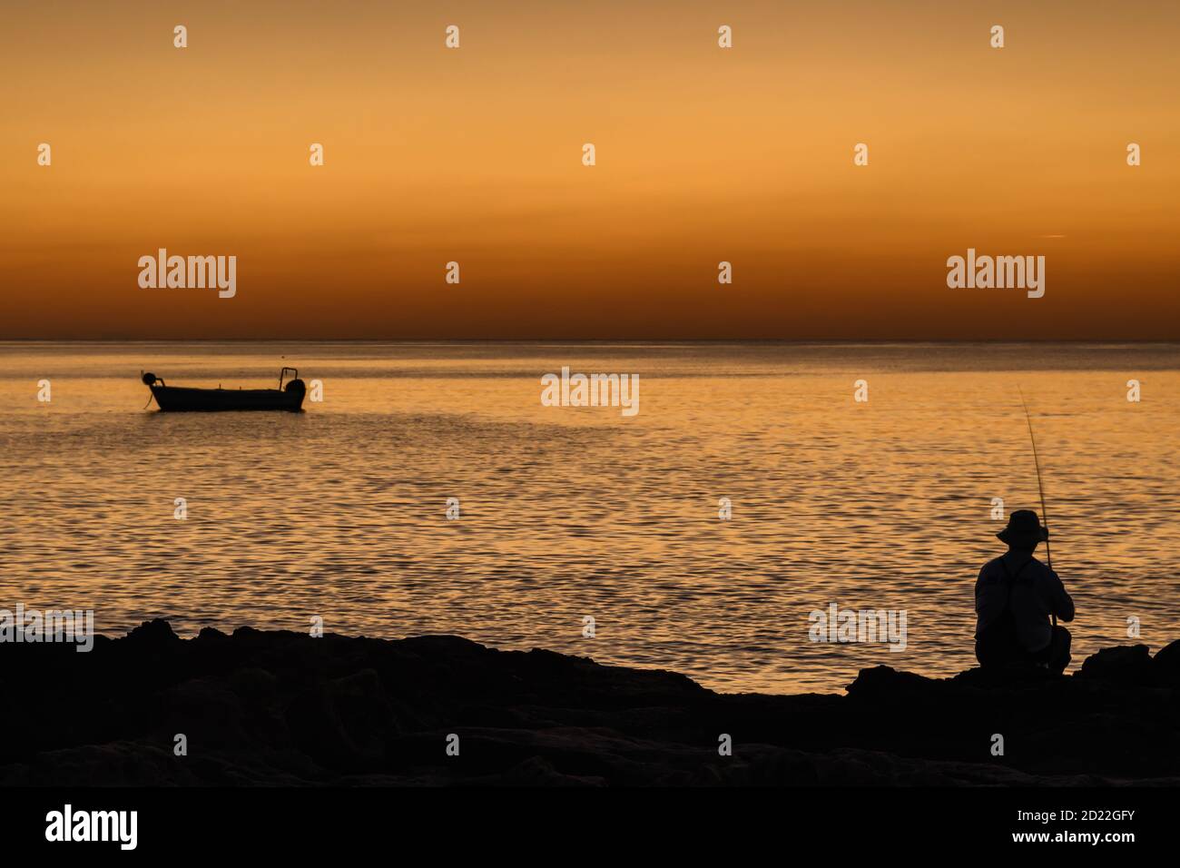 Mediterranean sunrise with a fisherman silhouette Stock Photo - Alamy