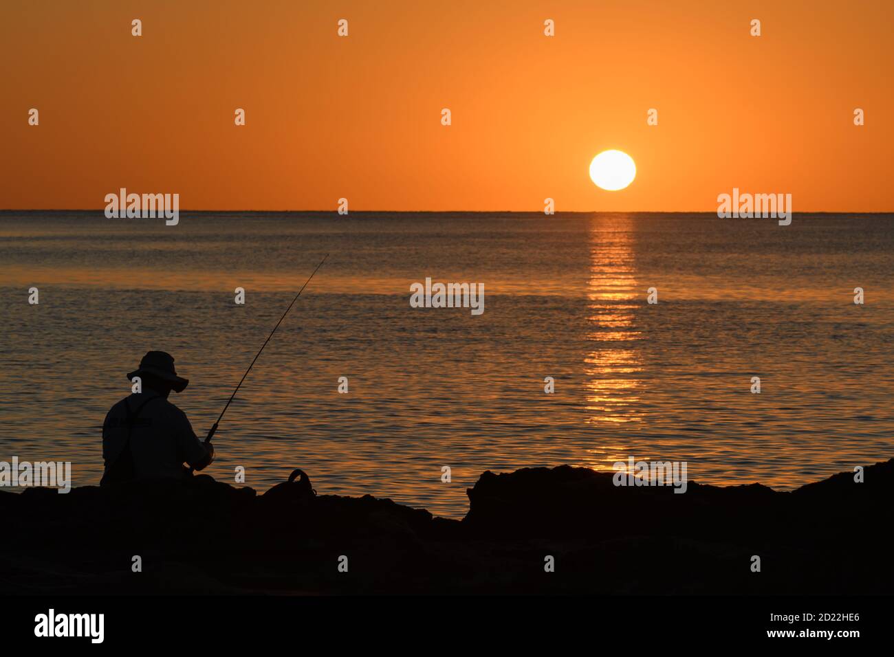 Mediterranean sunrise with a fisherman silhouette Stock Photo - Alamy