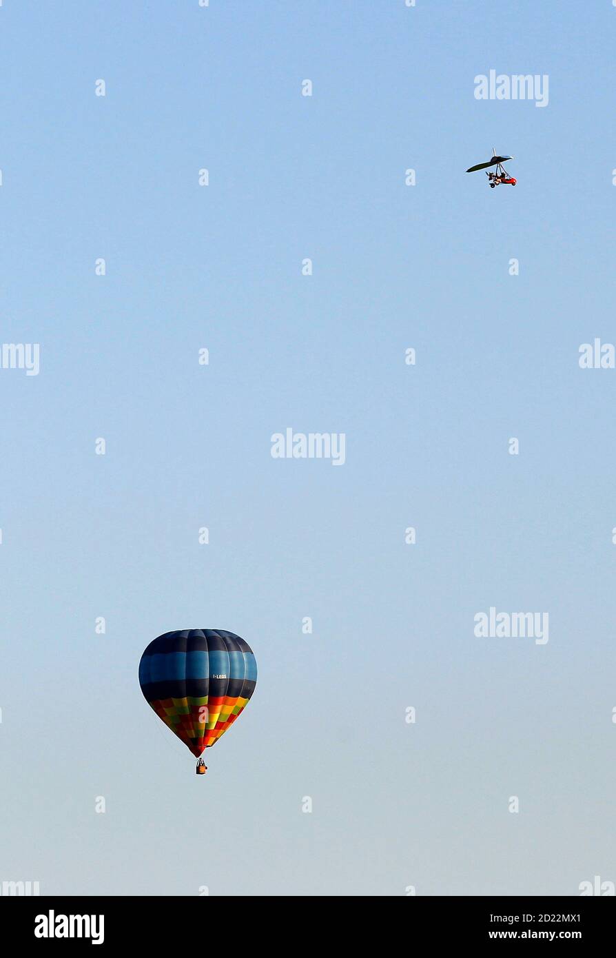 An ultralight aircraft flies near a hot air balloon over Alessandria May 22, 2010. REUTERS/Alessandro Bianchi (ITALY - Tags: SOCIETY TRANSPORT) Stock Photo
