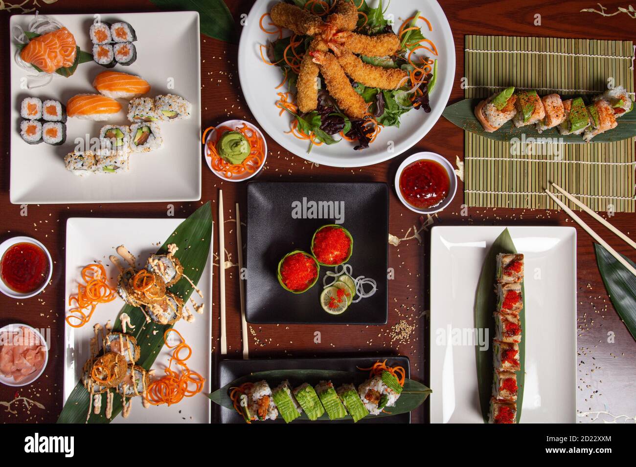 Assortment of typical Japanese dishes served at the restaurant table. Sushi, niguiri, tempura, maki. Stock Photo