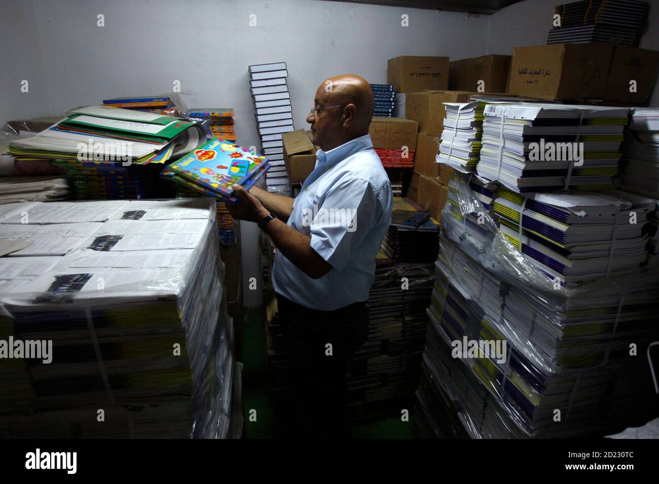 Israeli Saleh Abbasi holds children's books in his publishing house in the northern Israeli city of Haifa August 18, 2008. Abbasi says he wants to use his publishing business to foster cultural ties between Israel and its Arab neighbours, but his plan was dealt a setback by a ban on importing books from Lebanon and Syria. Israel has no diplomatic ties with Beirut and Damascus, so Abbasi, an Arab citizen of the Jewish state, has been using Jordan and Egypt as conduits to trade books with publishers in Lebanon and Syria. Picture taken August 18, 2008. To match feature ISRAEL-BOOKS/BAN  REUTERS/B Stock Photo