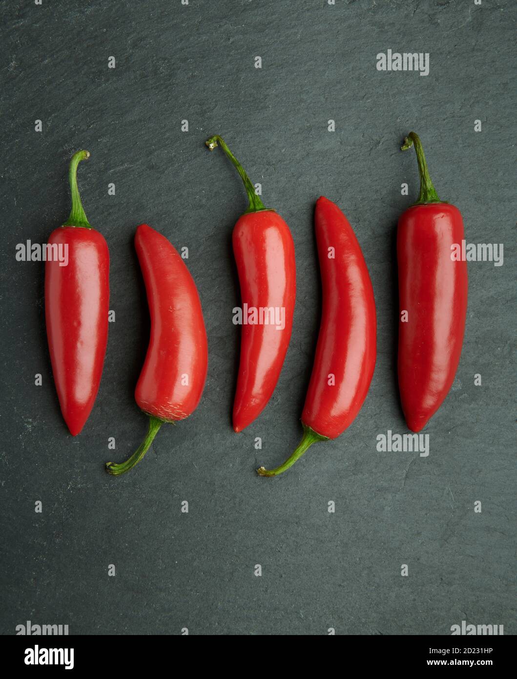 Chilli peppers on a natural slate background Stock Photo