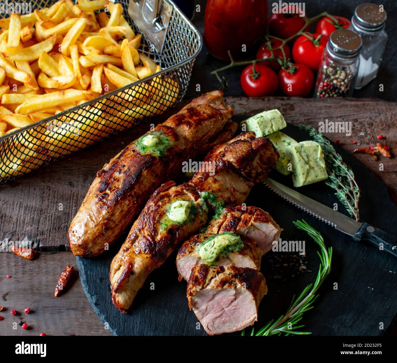 grilled pork dish with herb butter and homemade french fries in a