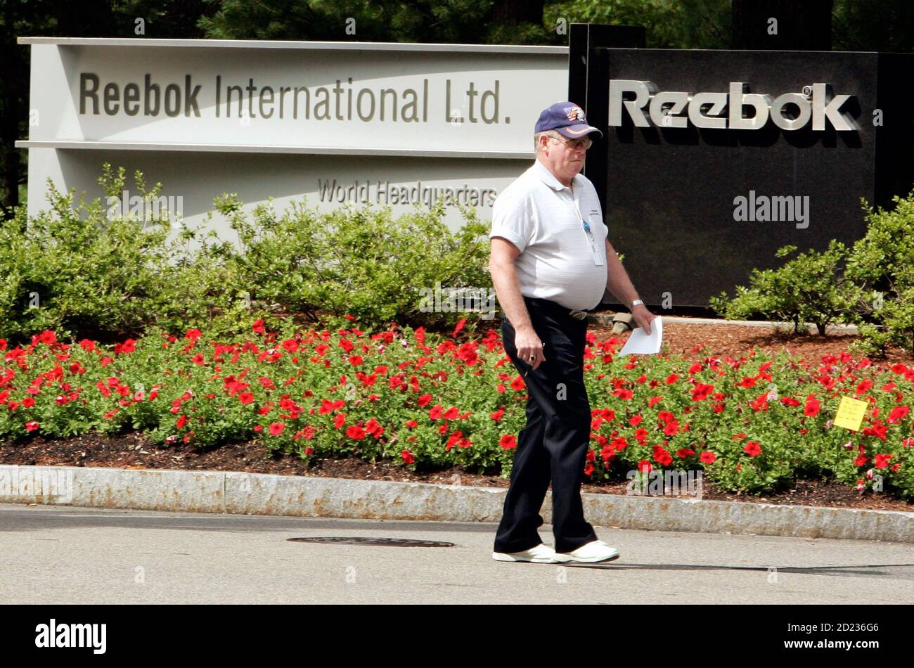 A security guard walks outside the world headquarters for Reebok in Canton,  Massachusetts August 3, 2005. Germany's Adidas-Salomon is to buy rival  sporting goods firm Reebok in a deal worth 3.1 billion