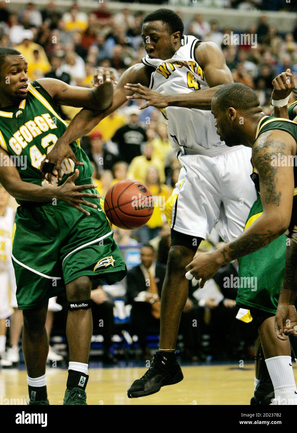 Wichita State's Ryan Martin (C) loses the ball to George Mason's Folarin  Campbell (L) and Jai Lewis (R) during their men's NCAA basketball regional  semifinal in Washington March 24, 2006. George Mason