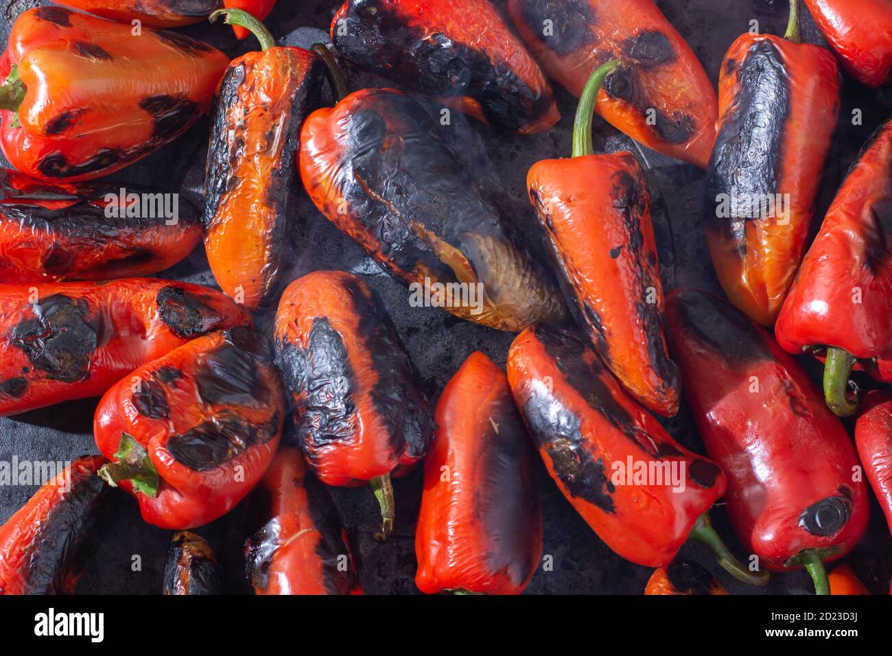 Red peppers roasting on a wood-fired stove in preparation for making ajvar, a traditional serbian dish Stock Photo
