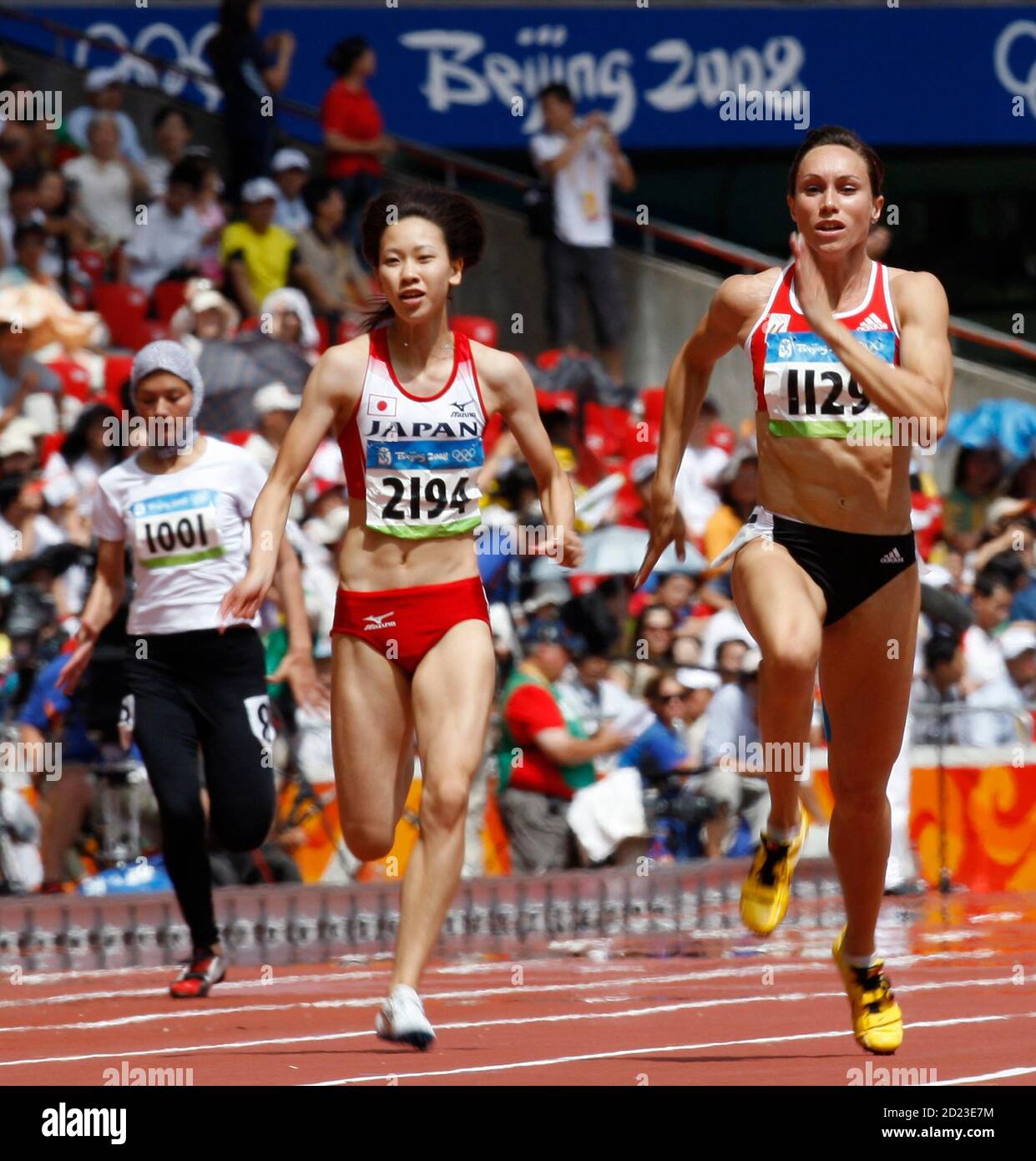 Chisato Fukushima of Japan (C) and Kim Gevaert of Belgium (R) sprint past  Robina Muqimyar of Afghanistan in their women's 100m heat in the athletics  competition of the Beijing 2008 Olympic Games