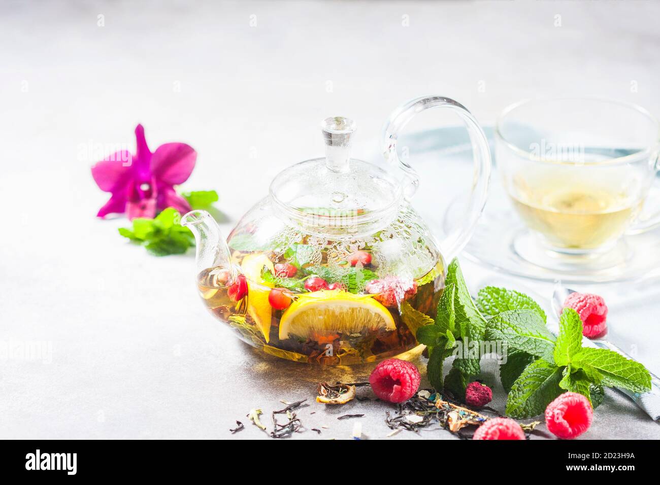 Hot herbal tea with lemon, raspberries and mint. Healthy lemon tea. Stock Photo