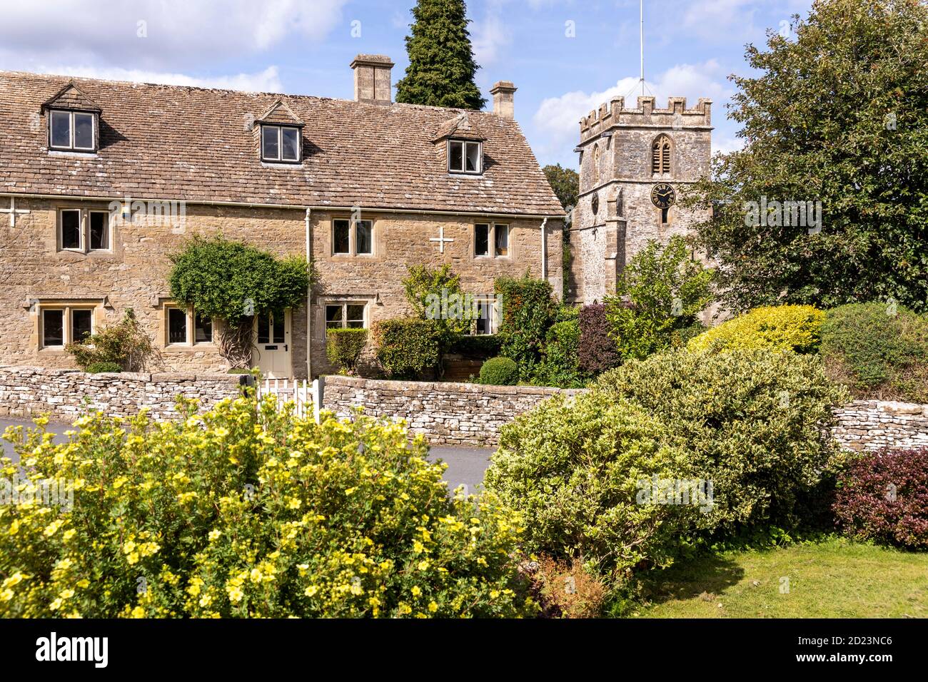 An old stone farmhouse next to St Andrews church in the Cotswold village of Miserden, Gloucestershire UK Stock Photo