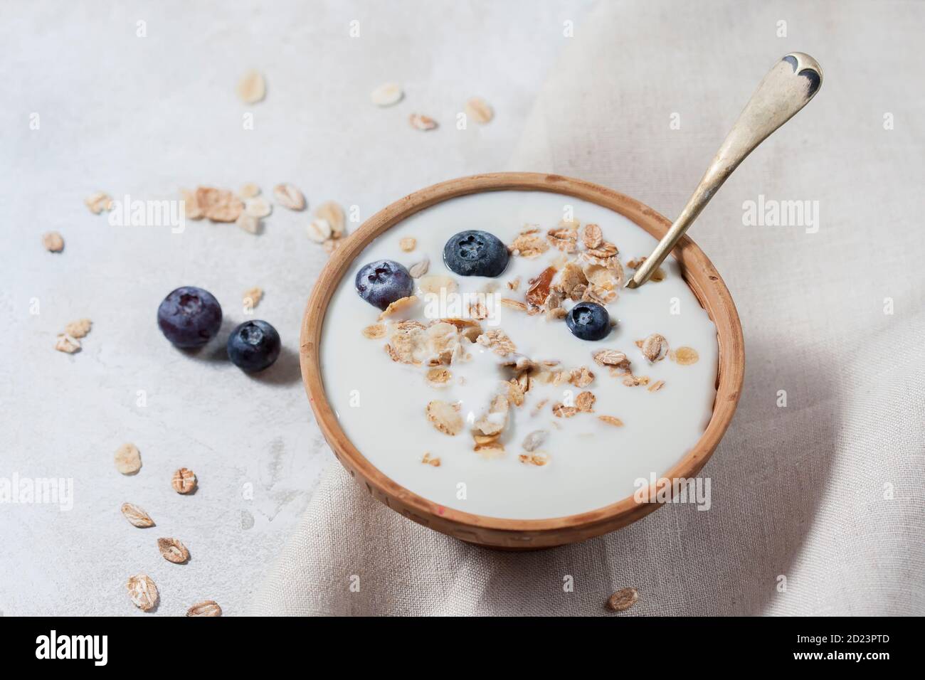Homemade yogurt with granola and berries in a ceramic bowl on a light background. Concept healthy breakfast. Stock Photo