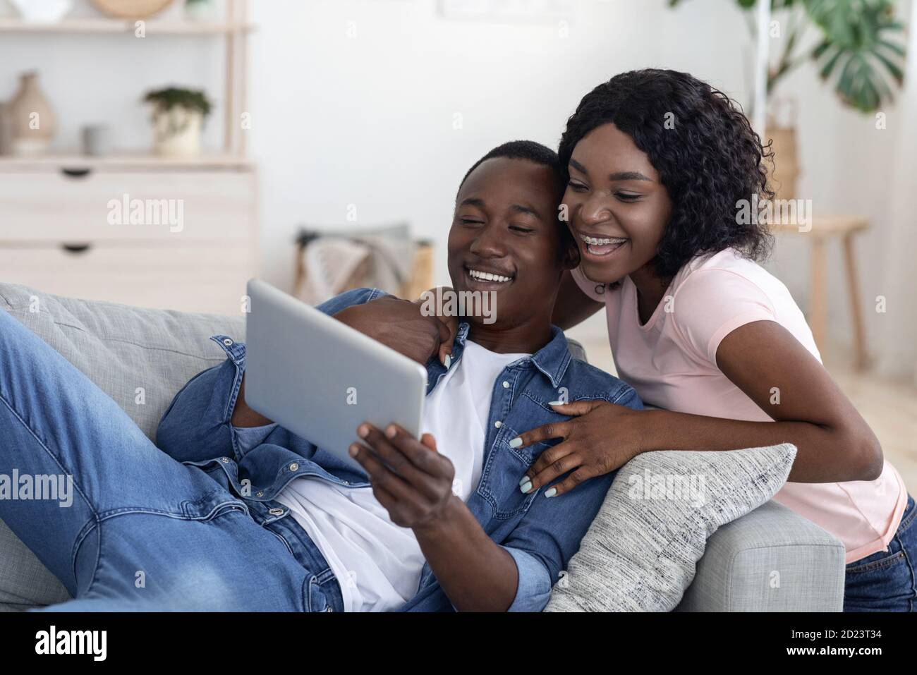 Cheerful black couple using digital tablet at home Stock Photo