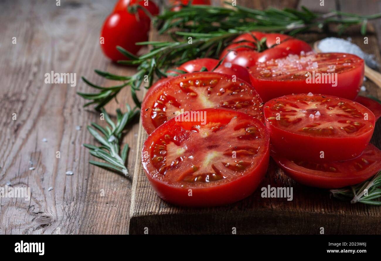 Sliced Tomato. Red tomatoes on a Wooden Cutting Board. Stock Photo