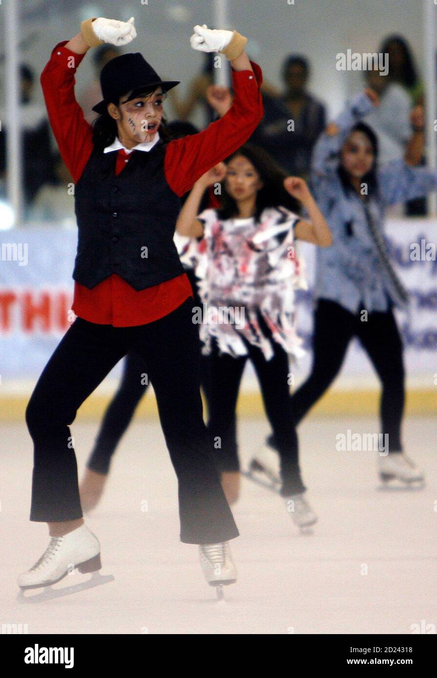 A professional skater wearing a Michael Jackson outfit dances with her  dance group to the tune of "Thriller" in tribute to the legendary "king of  pop" at a skating rink inside a