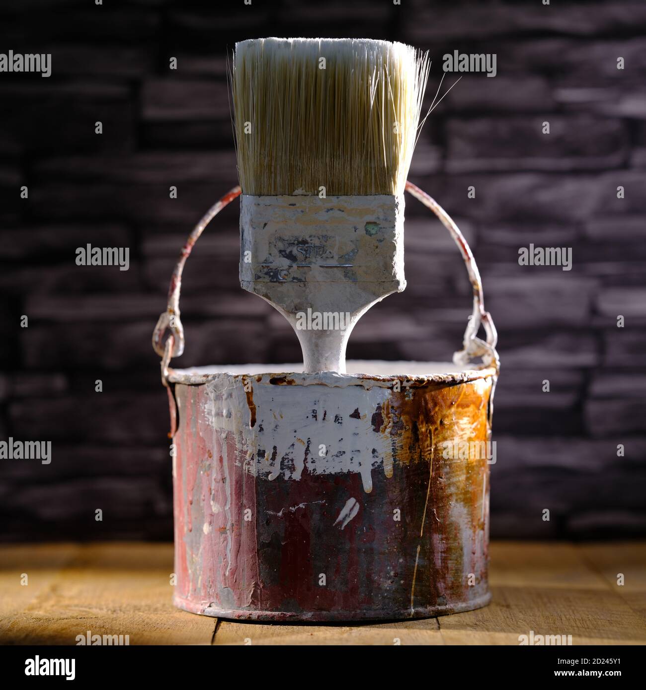 Paint tin bucket splattered with red and white paint with old paint
