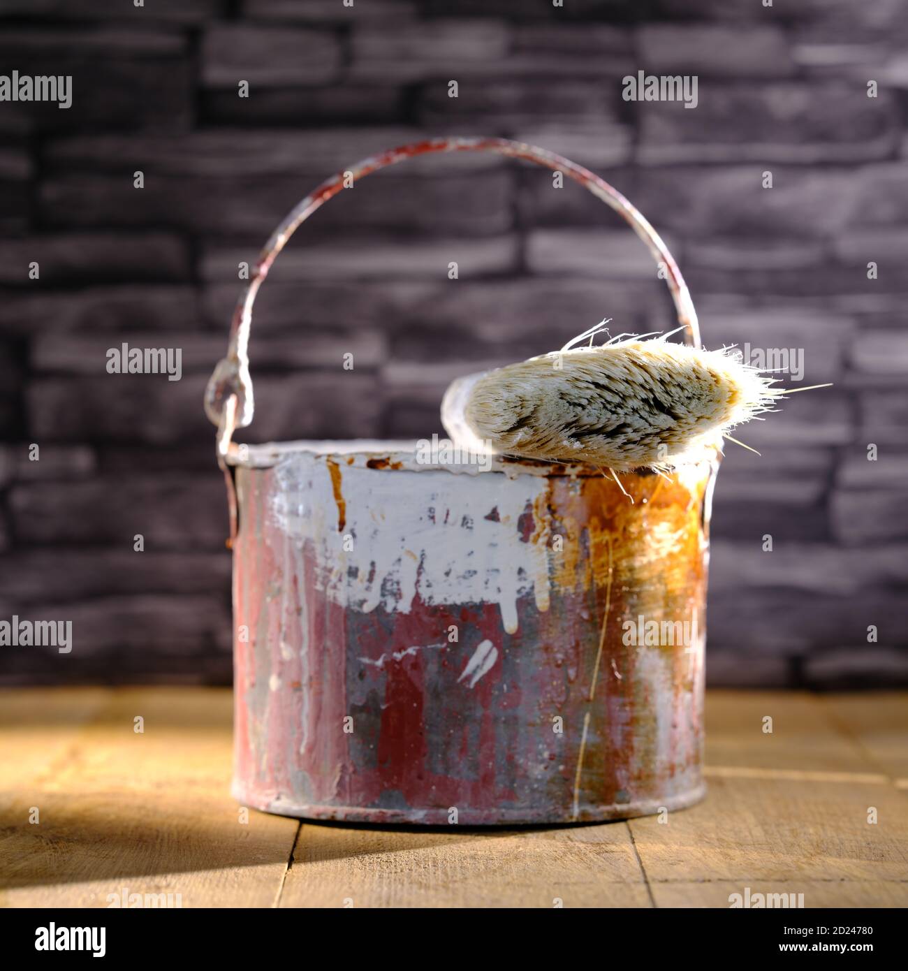 Paint tin bucket splattered with red and white paint with old paint
