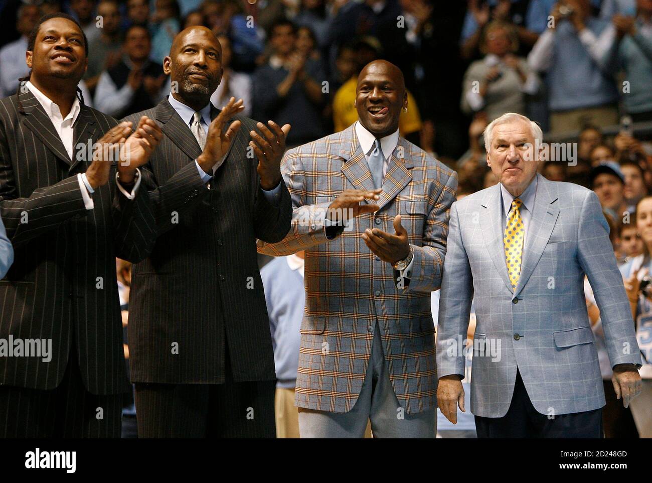 Former University of North Carolina players Sam Perkins, James Worthy, and  Michael Jordan, along with former North Carolina head basketball coach Dean  Smith (L-R) watch a presentation during a ceremony honoring the