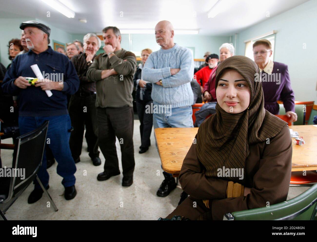 Hiba Nazar (R) sits as she and a group of Muslim women meet residents of the Quebec town of Herouxville February 11, 2007. The Muslim group met with the residents to voice their objection to the town council's recently passed code of social norms that new immigrants would have to adhere to.   REUTERS/Shaun Best        (CANADA) Stock Photo