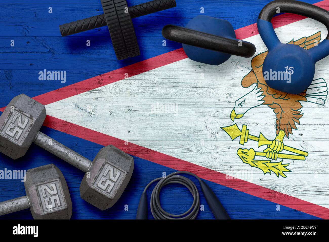 American Samoa sports club concept. Top view of heavy weight plates with iron bar on national background. Stock Photo