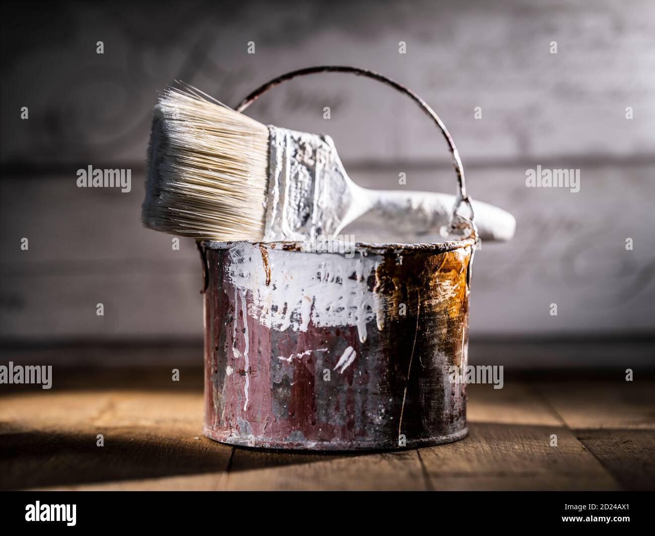 Paint tin bucket splattered with red and white paint with old paint