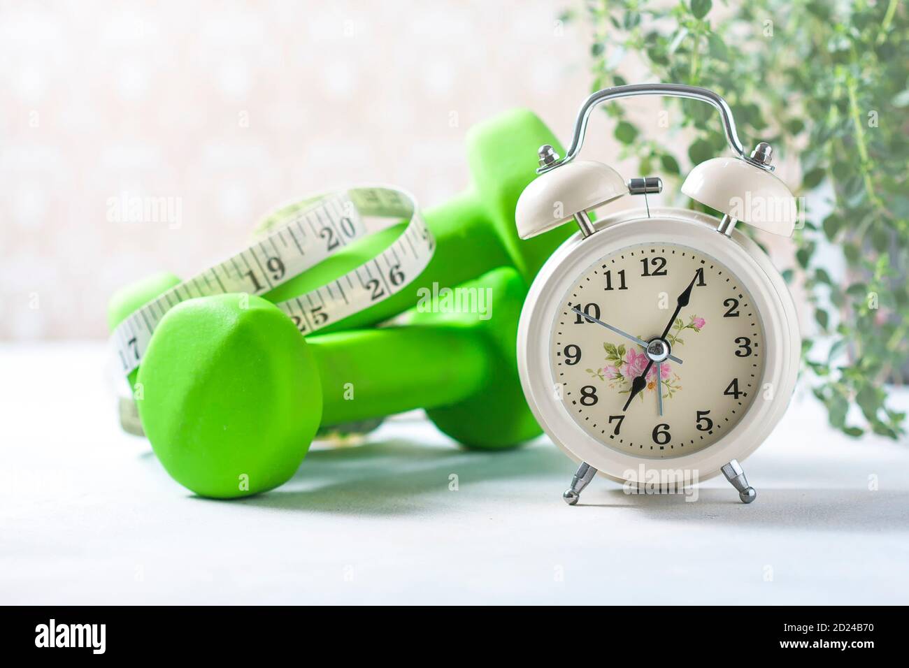 Alarm clock, measuring tape and dumbbells, concept of diet Stock Photo -  Alamy