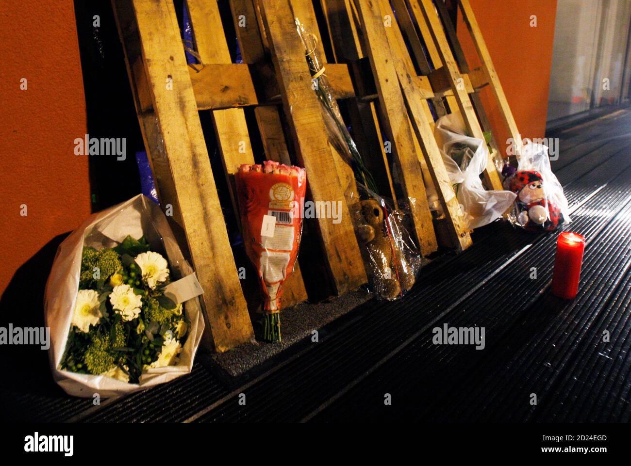 A candle and flowers are laid at the entrance of a creche in which a knife attack occurred in Dendermonde January 23, 2009. A man with a white painted face and blackened eyes stabbed to death two infants and a woman and injured 13 at a nursery in western Belgium on Friday before cycling away.      REUTERS/Francois Lenoir (BELGIUM) Stock Photo