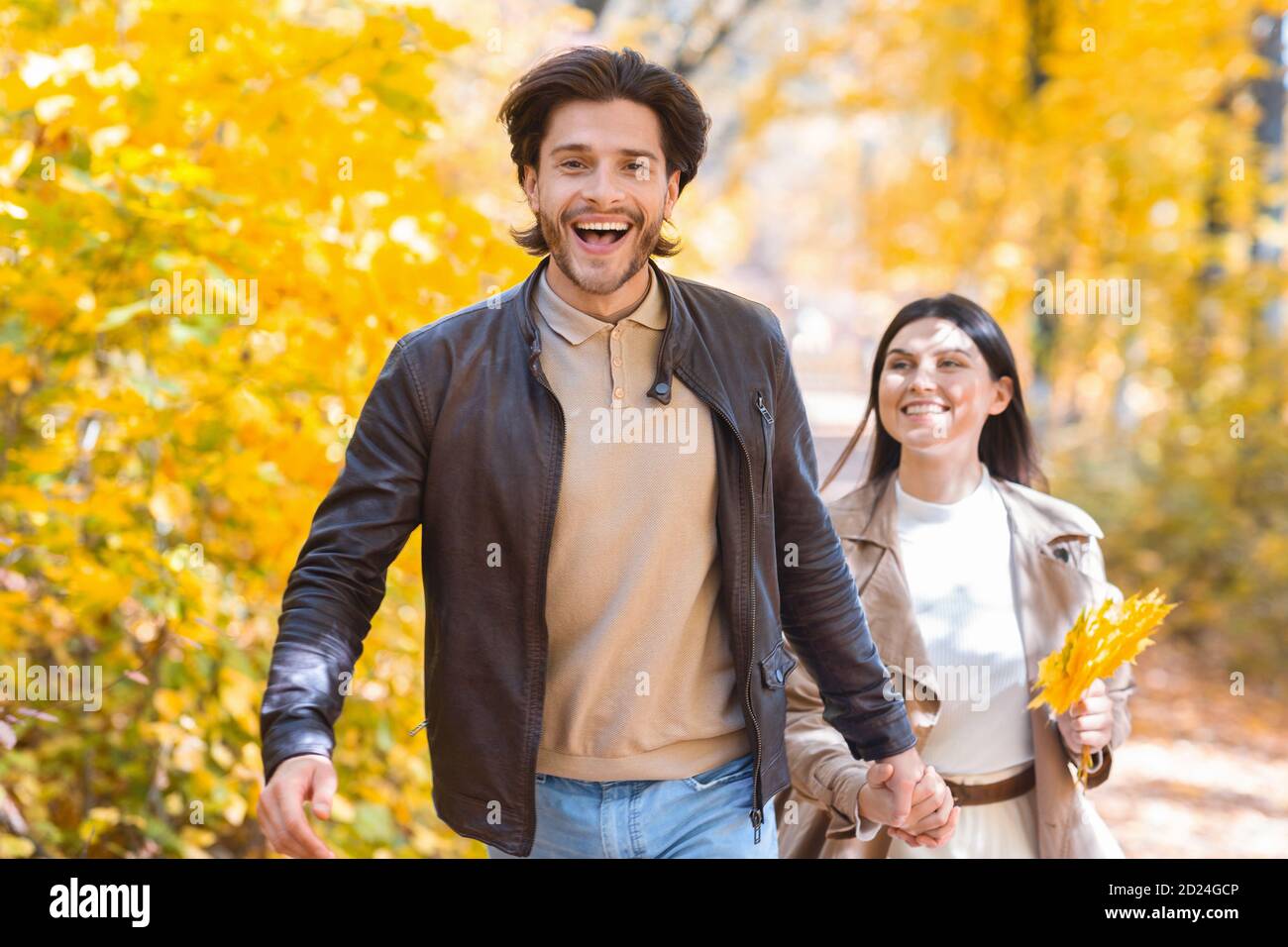 Emotional guy running buy golden forest with his girlfriend Stock Photo