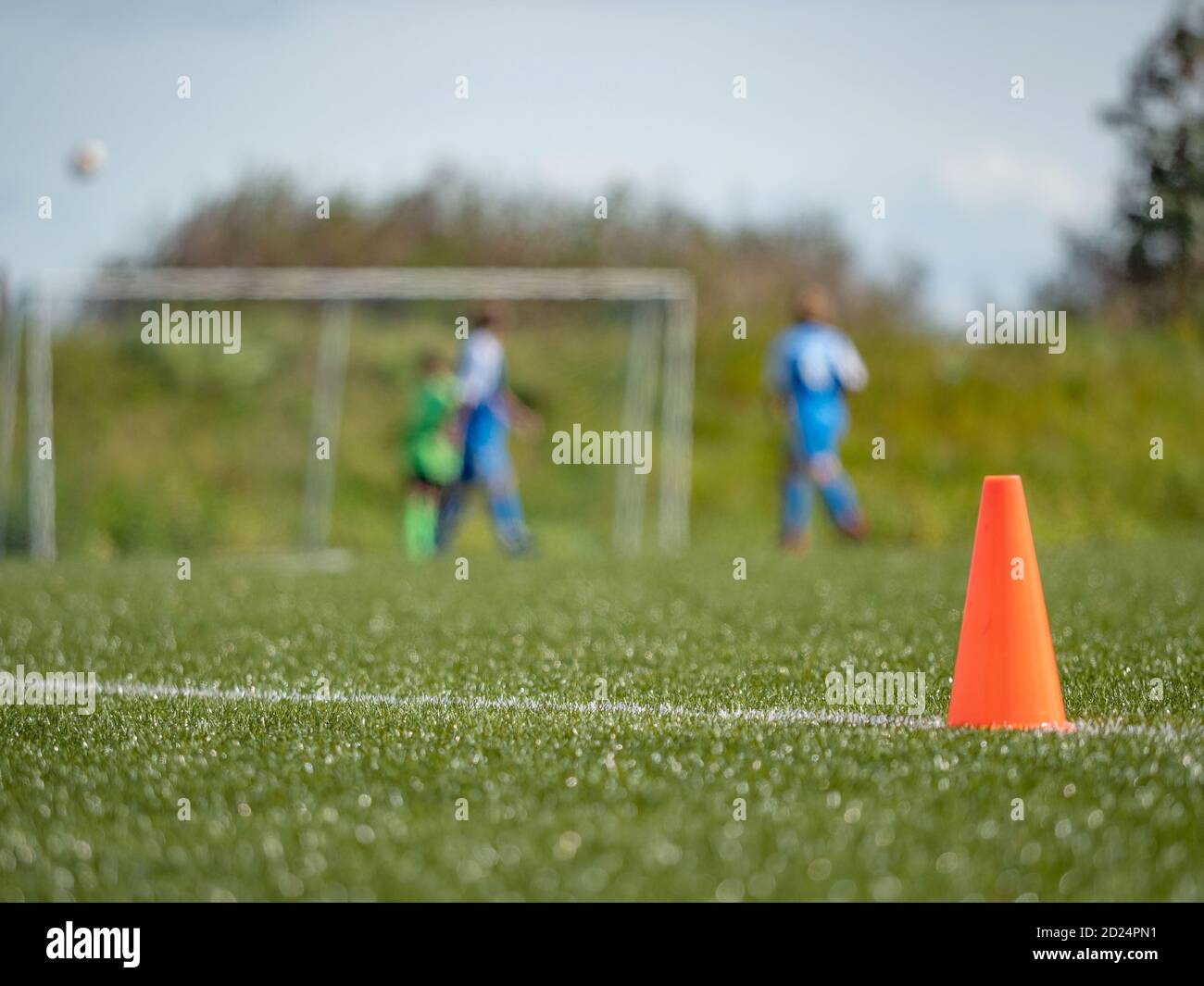 Side line of an outdoor football training field. Orange cone signal