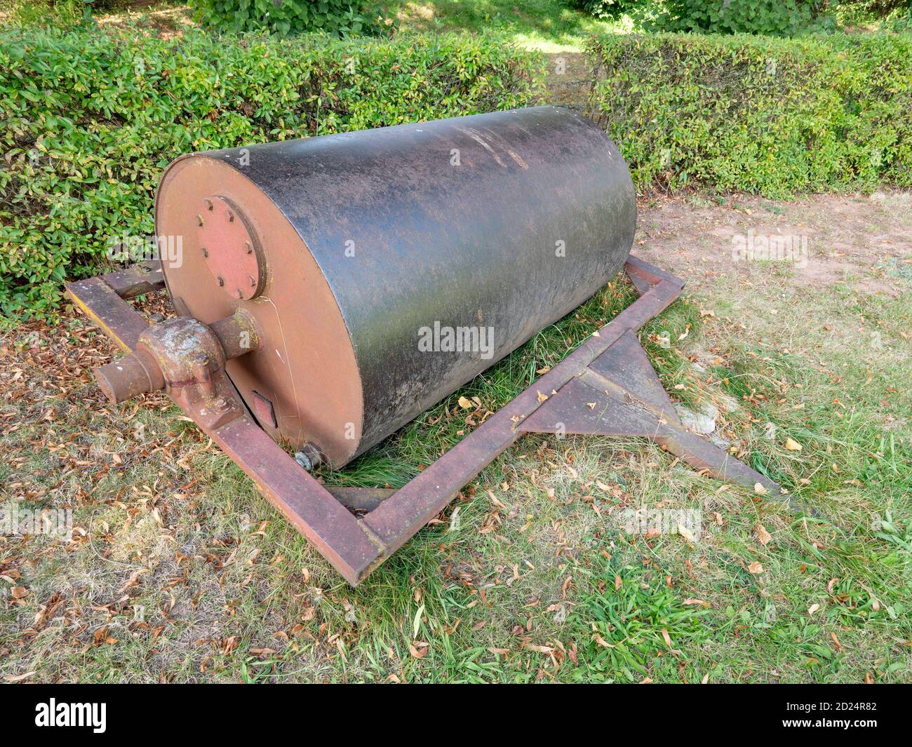Steel old grass roller on grass yard. Lawn Roller for levelling