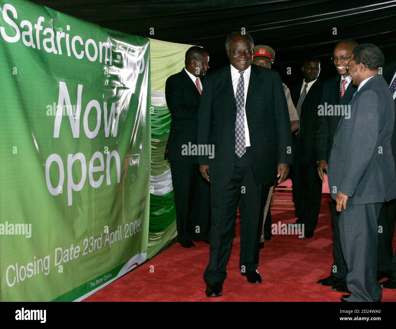 Kenya's President Mwai Kibaki (C) chats with delegates after launching the Safaricom Initial Public Offer (IPO) in Nairobi March 28, 2008. Thousands of Kenyans queued to buy shares in mobile phone firm Safaricom on Friday, shrugging off calls for east Africa's biggest IPO to be delayed until a riddle over a mysterious third shareholder was resolved. In a sign of returning stability in Kenya after a bloody post-election crisis, the government is offloading a 25 percent stake worth at least 50 billion shillings ($779.4 million) in Safaricom. It had held 60 percent in Safaricom. REUTERS/Antony Nj Stock Photo